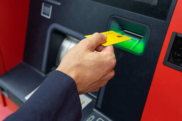 Von oben: anonyme männliche Person, die eine leere kontaktlose Kreditkarte an einem Geldautomaten in der Stadt benutzt - ADSF42237