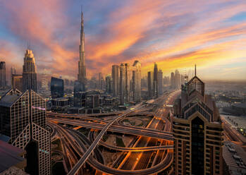 Luftaufnahme der Innenstadt mit modernen Wolkenkratzern in der Nähe der Autobahn in Dubai bei Sonnenuntergang bunten Himmel - ADSF42347
