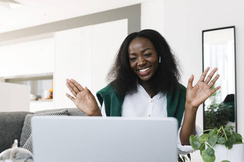 Happy freelancer waving on video call at home - TYF00564