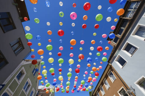 Germany, Bavaria, Kempten, Colorful paper lanterns hanging against clear blue sky - WIF04676