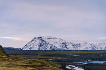 Scenic view of snowy mountains in winter under cloudy sky at sunset in Vik, Iceland - ADSF42608