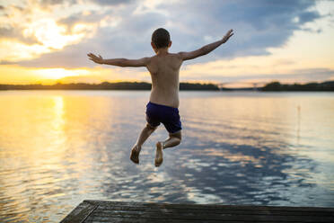 Boy diving into lake at sunset - FOLF11966