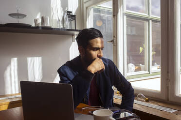 Mann mit Laptop denkt am Fenster - FOLF12038