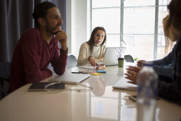 Coworkers sitting at meeting table in office - FOLF12052