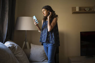 Mädchen benutzt Smartphone im Wohnzimmer - FOLF12106