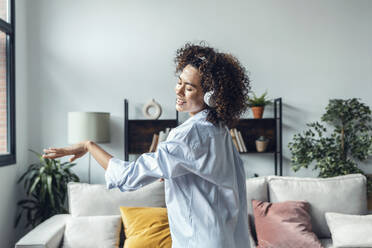 Happy young woman dancing and enjoying at home - JSRF02324