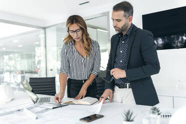 Business colleagues making plans in office - JSRF02360