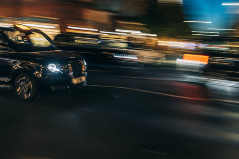 UK, England, London, Unscharfe Bewegung eines fahrenden Taxis und umliegender Verkehr bei Nacht - IFRF01904