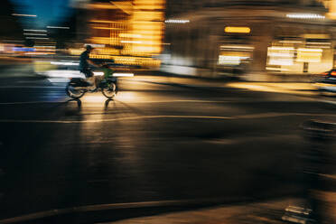 UK, England, London, Blurred motion of person riding motorcycle along city street at night - IFRF01906