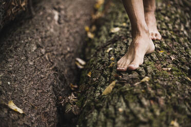 Man walking on tree log - UUF27914