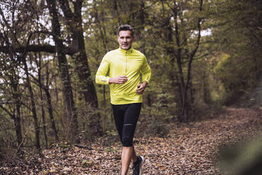 Lächelnder reifer Mann beim Joggen im Wald - UUF27922