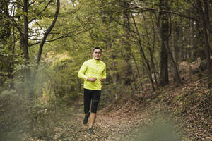 Active mature man jogging in forest - UUF27924