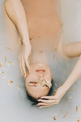 Mädchen beim Baden mit Blumen in der Badewanne - VSNF00292