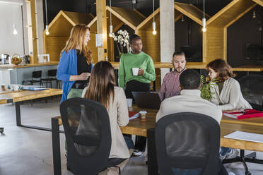 Geschäftsleute und Geschäftsfrauen besprechen Strategie am Schreibtisch im Büro - LJF02429