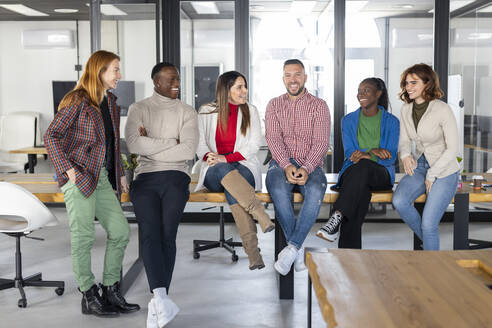 Glückliche multirassische Geschäftsleute und Geschäftsfrauen verbringen Zeit miteinander in einem Coworking-Büro - LJF02433