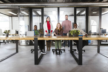 Smiling multiracial businesswomen and businessmen at coworking office - LJF02439