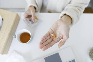 Hand of woman holding capsule pill - TYF00583