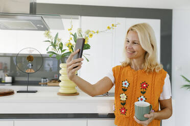 Glückliche Frau nimmt Selfie durch Smartphone zu Hause - TYF00600
