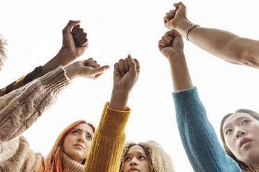 Multiracial women making fist at protest - JCCMF08640