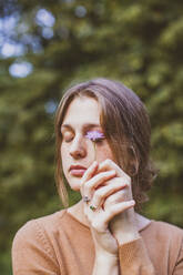 Woman touching closed eyes with flower - OSF01298