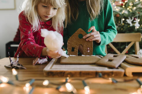 Schwestern dekorieren Lebkuchenhaus zu Hause - TYF00633