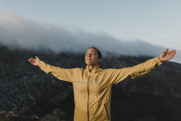 Woman with eyes closed standing at Caldera Blanca volcano, Lanzarote, Canary Islands, Spain - DMGF00952