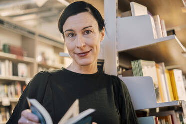 Woman with book in library - AMWF01073