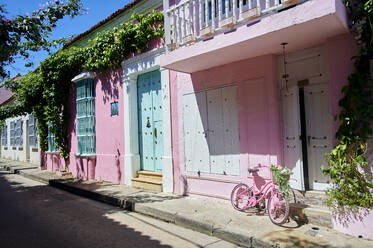 Pink bicycle in front of house on footpath - KIJF04516