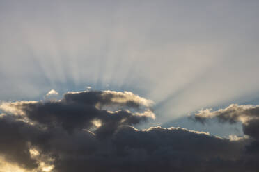 Graue Wolken, die vom Sonnenlicht durchdrungen werden - RUEF03909