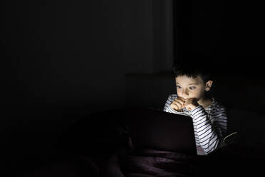 Junge sieht sich zu Hause auf dem Laptop einen Gruselfilm an - LJF02450