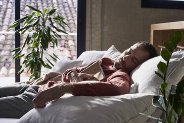 Mann schlafend mit Buch auf der Brust zu Hause - VEGF06152