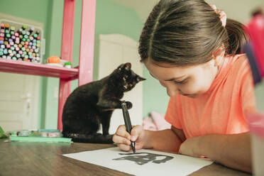 Mädchen zeichnet Katze Bild auf Papier zu Hause - OSF01317