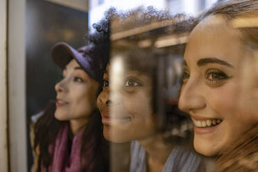 Happy multiracial friends seen through glass - JCCMF08664