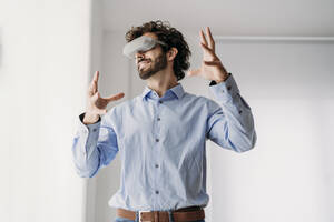 Ingenieur mit VR-Brille gestikuliert im Büro - EBBF07597
