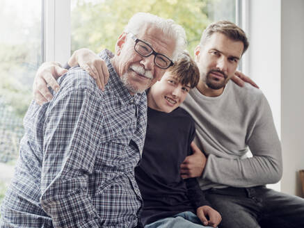 Großvater, Vater und Sohn sitzen zu Hause am Fenster - PWF00450