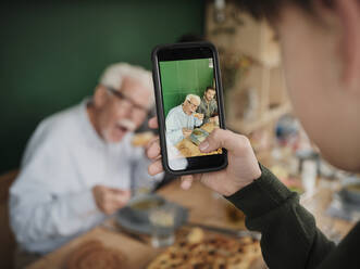 Enkel filmt Vater und Großvater beim Mittagessen mit einem Telefon - PWF00501