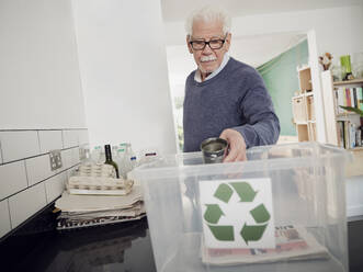 Älterer Mann legt getrennten Abfall in die Recyclingbox - PWF00532