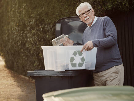 Älterer Mann wirft getrennten Recycling-Müll in die Mülltonne - PWF00548