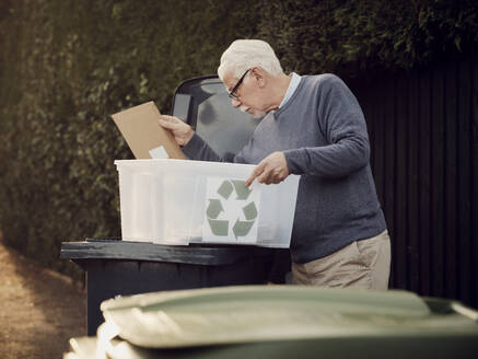 Älterer Mann wirft getrennten Recycling-Müll in die Mülltonne - PWF00549