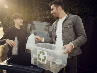 Vater und Sohn werfen getrennte Abfälle in die Mülltonne - PWF00551