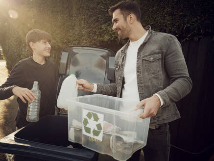 Vater und Sohn werfen getrennte Abfälle in die Mülltonne - PWF00551
