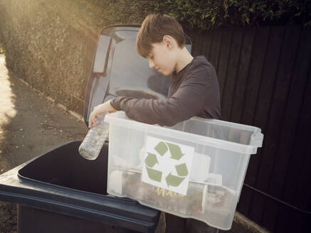 Junge wirft getrennten Recycling-Müll in die Mülltonne - PWF00552