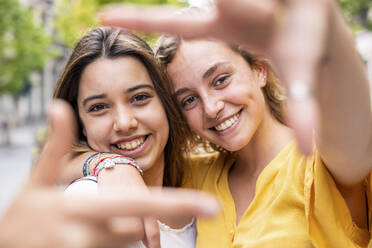 Glückliche junge Freunde machen Fingerrahmen - WPEF06869