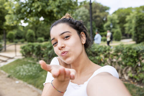 Frau gestikuliert und macht Selfie im Park - WPEF06890