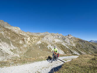 Mann fährt Mountainbike auf einem Weg im Vanoise-Nationalpark, Frankreich - LAF02804