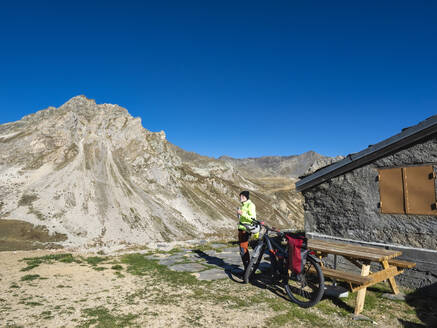 Älterer Mann auf dem Fahrrad vor blauem Himmel im Vanoise-Nationalpark, Frankreich - LAF02809