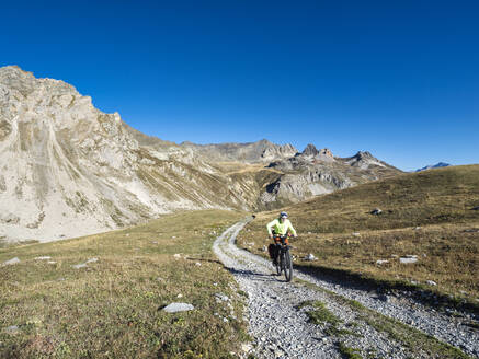 Älterer Mann fährt Mountainbike an einem sonnigen Tag im Vanoise-Nationalpark, Frankreich - LAF02814