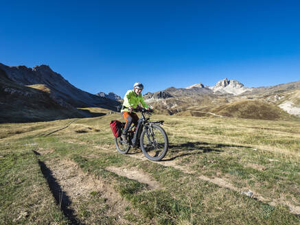 Senior man riding mountain bike on pathway, Vanoise National Park, France - LAF02815