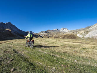 Senior man riding mountain bike on pathway, Vanoise National Park, France - LAF02816