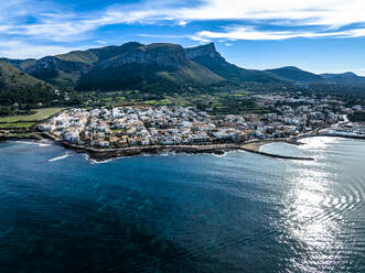 Aerial view of mountain ranges with town and sea under blue sky, Colonia de Sant Pere, Arta, Majorca, Spain - AMF09792